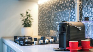 A kitchen with a coffee maker, two red cups, and a potted plant. - Stylish apartment with AC in the heart of Riga Centre (Riga)