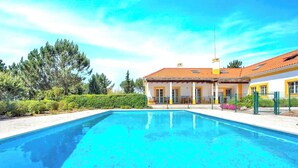 Une piscine avec une maison en arrière-plan.