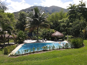 A pool surrounded by lush greenery and a mountain in the background. - Finca La Verbena - The Sound of Nature (San Jerónimo)