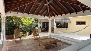 A covered outdoor seating area with a hammock, wooden chairs, and a sofa. - Finca La Verbena - The Sound of Nature (San Jerónimo)