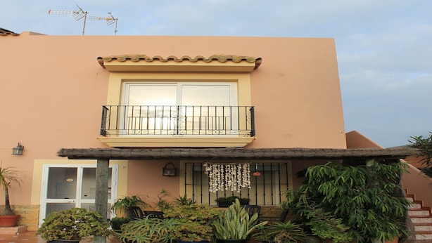 A two-story building with a balcony, potted plants, and a tiled roof. - La Torre del Palmar. (El Palmar)