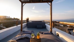 A rooftop terrace with a view of the sea, a wooden pergola, and a seating area with cushions and a drink. - Noelia Suites - Prive by ΜΡS (OIA)