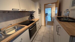 Eine moderne Küche mit Spüle, Herd, Backofen und Holzarbeitsplatten.