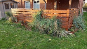 Un bâtiment en briques doté d’une terrasse en bois et d’un petit abri de jardin.