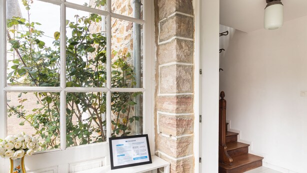 Ein Zimmer mit Fenster, weißem Regal und einer Treppe.