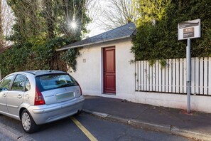 A silver car parked in front of a building with a red door and a sign indicating the address 6282.