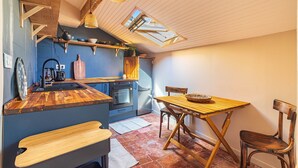 Una cucina compatta con piani in legno, un tavolo da pranzo e una panca.