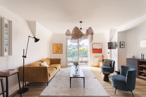 A modern living room with a sofa, coffee table, and chairs, a floor lamp, and a unique hanging light fixture. - La Dahouëtine - Blacon Vue sur Étang (Pléneuf-Val-André)