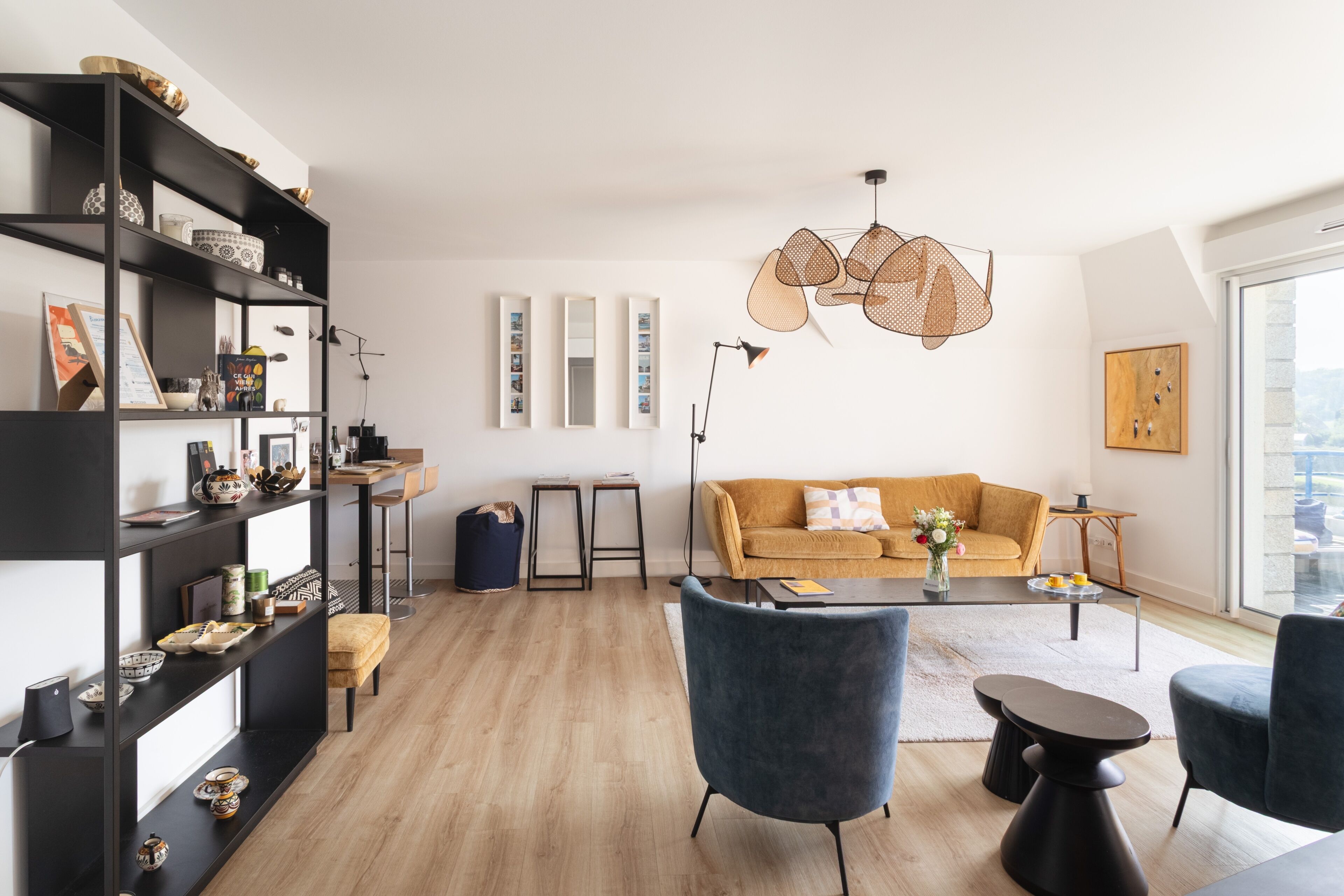 A modern living room with a sofa, chairs, a coffee table, and a bookshelf.