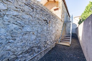 A stone wall with a metal staircase leading to a building. - MCC House - Avec terrasse privée (Quillan)