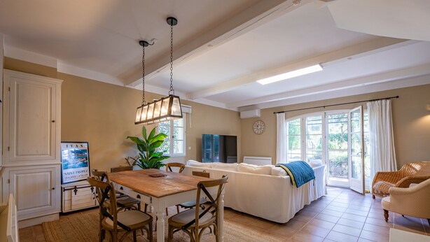 A spacious living area with a dining table, chairs, a sofa, and a TV. - La Bastide Saint Endreol - Avec Parking Privé (La Motte)
