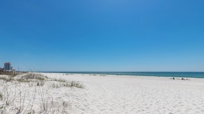 Ein weiter Sandstrand mit blauem, klarem Himmel.