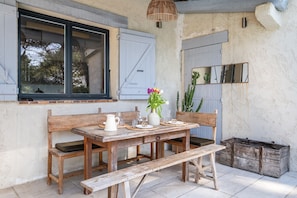 Un tavolo in legno rustico con panche, un vaso con fiori e una lampada dallo stile rustico.