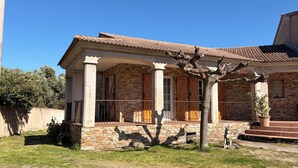Ein Haus aus Stein mit Ziegeldach und einer Veranda, sowie eine Statue eines Pferdes.