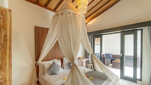 Een slaapkamer met een hemelbed, houten plafond en uitzicht op het terras.