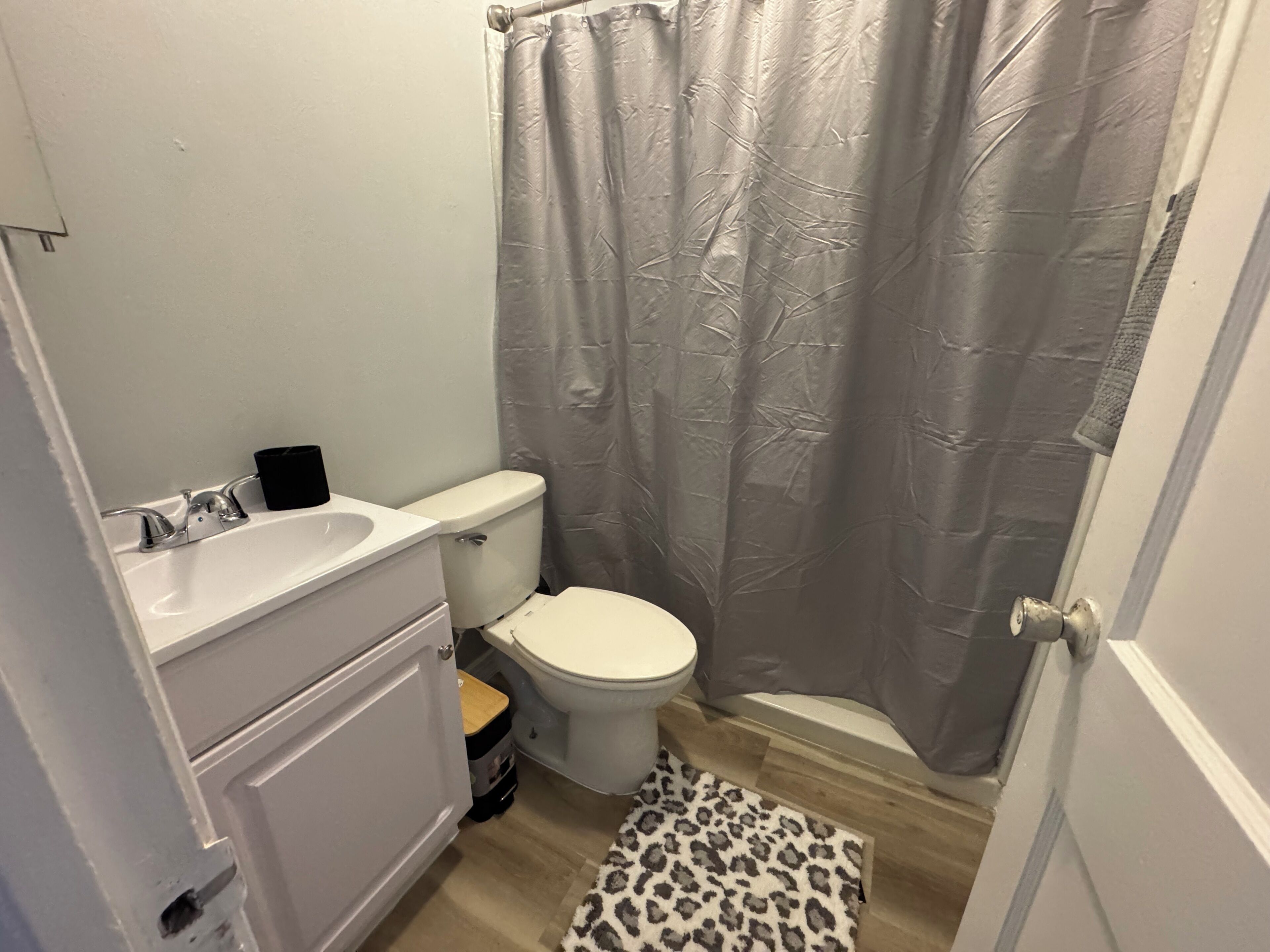 A bathroom with a toilet, sink, and shower curtain.