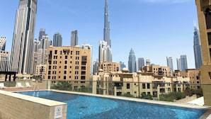 Une piscine sur le toit offrant une vue panoramique sur la ville, avec notamment des immeubles modernes de grande hauteur.