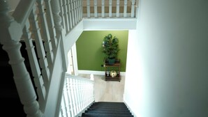 A staircase with white balusters, a green wall, and a Christmas tree. - Modern Self-Contained Studios near Alexandra Palace & Wood Green (London)