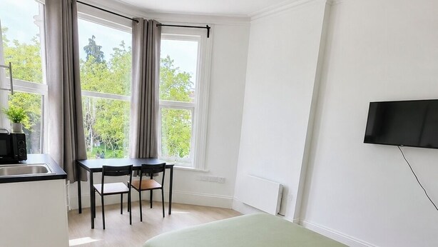 A bedroom with a bed, a desk, and a chair. - Modern Self-Contained Studios near Alexandra Palace & Wood Green (London)