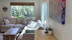Uma sala de estar moderna com sofá, mesa de centro e obra de arte na parede.