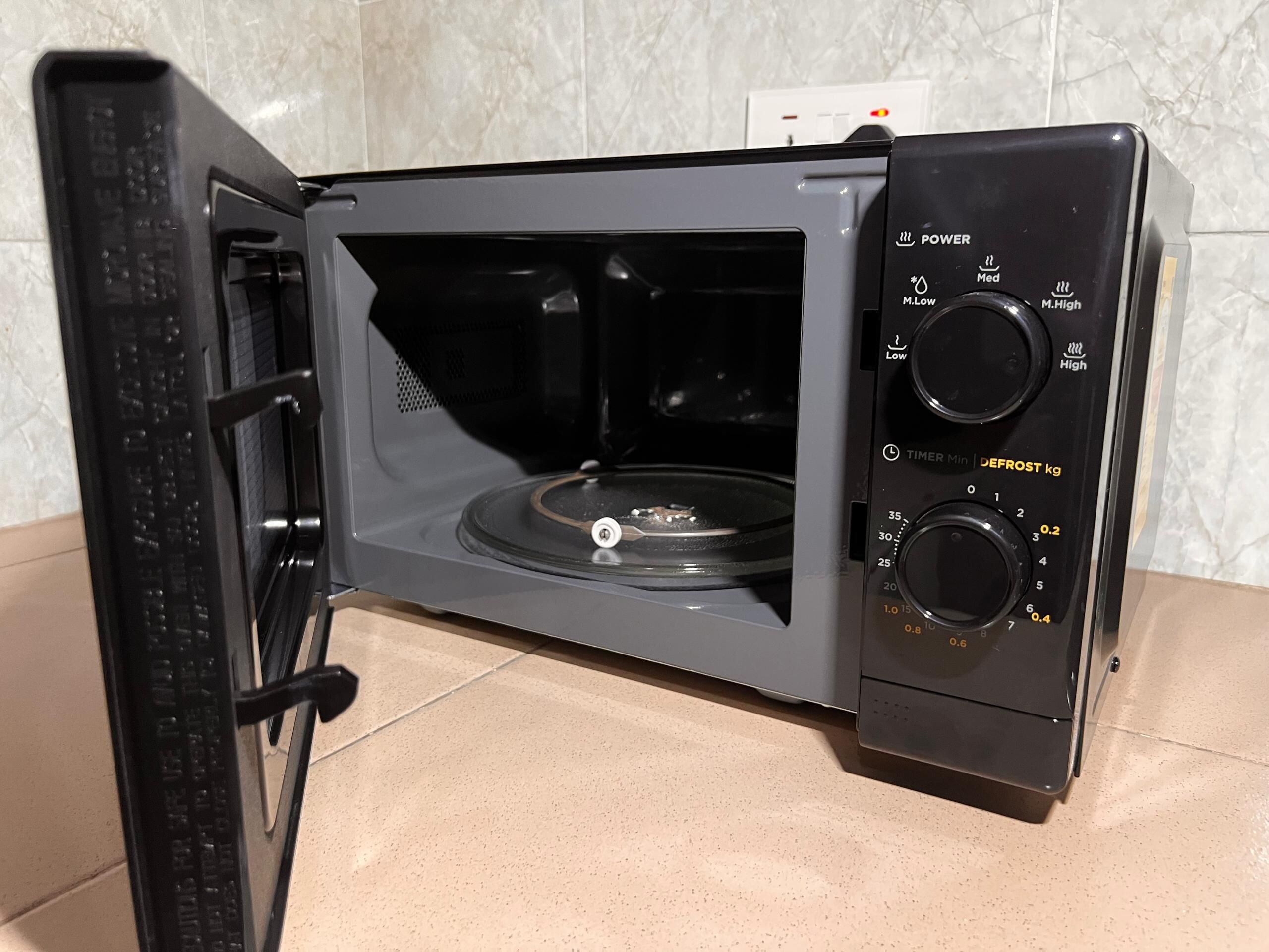 Un horno microondas con temporizador digital y ajustes de potencia.