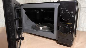 Un horno microondas con temporizador digital y ajustes de potencia.
