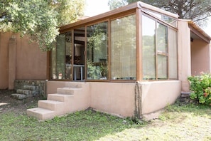 A building with a glass enclosure, a set of concrete steps, and a stone wall.