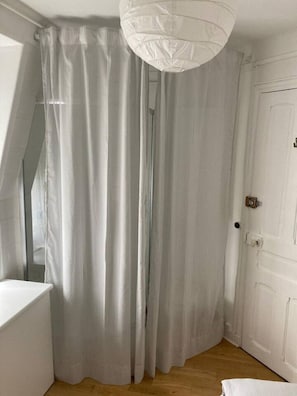 A room with a white door, a white ceiling light fixture, and a corner with a white bench. - Parc Montsouris - In a pretty square - Studio (Paris)