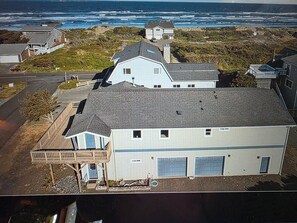 A coastal house with a garage, a balcony, and a view of the ocean.