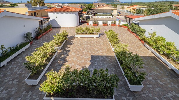 A rooftop terrace with potted plants, a paved area, and surrounding buildings. - Apartment 'Bella Vista Su Tavolara 4' with Tavolara View, Wi-Fi and Air Conditioning (Porto San Paolo)