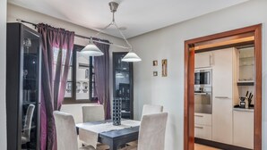 Een eethoek met een tafel, stoelen en een kroonluchter.