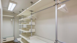 Een hotelkamer met een inbouwkast, douche en bed.