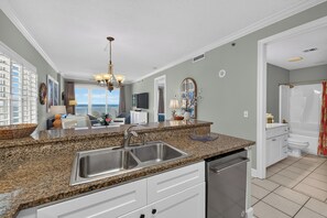 A kitchen with granite countertops, stainless steel sink, and a dishwasher. - Corner Condo - 3 bedroom/3 bath - Beautiful direct view of Gulf of America (Gulf Shores)