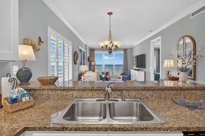 A kitchen with granite countertops, stainless steel sink, and a chandelier. - Corner Condo - 3 bedroom/3 bath - Beautiful direct view of Gulf of America (Gulf Shores)
