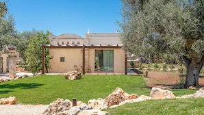 A modern house with a patio, outdoor seating, and a well-maintained lawn. - Le Camere di Corte Kalia by Raro Rooms (Francavilla Fontana)