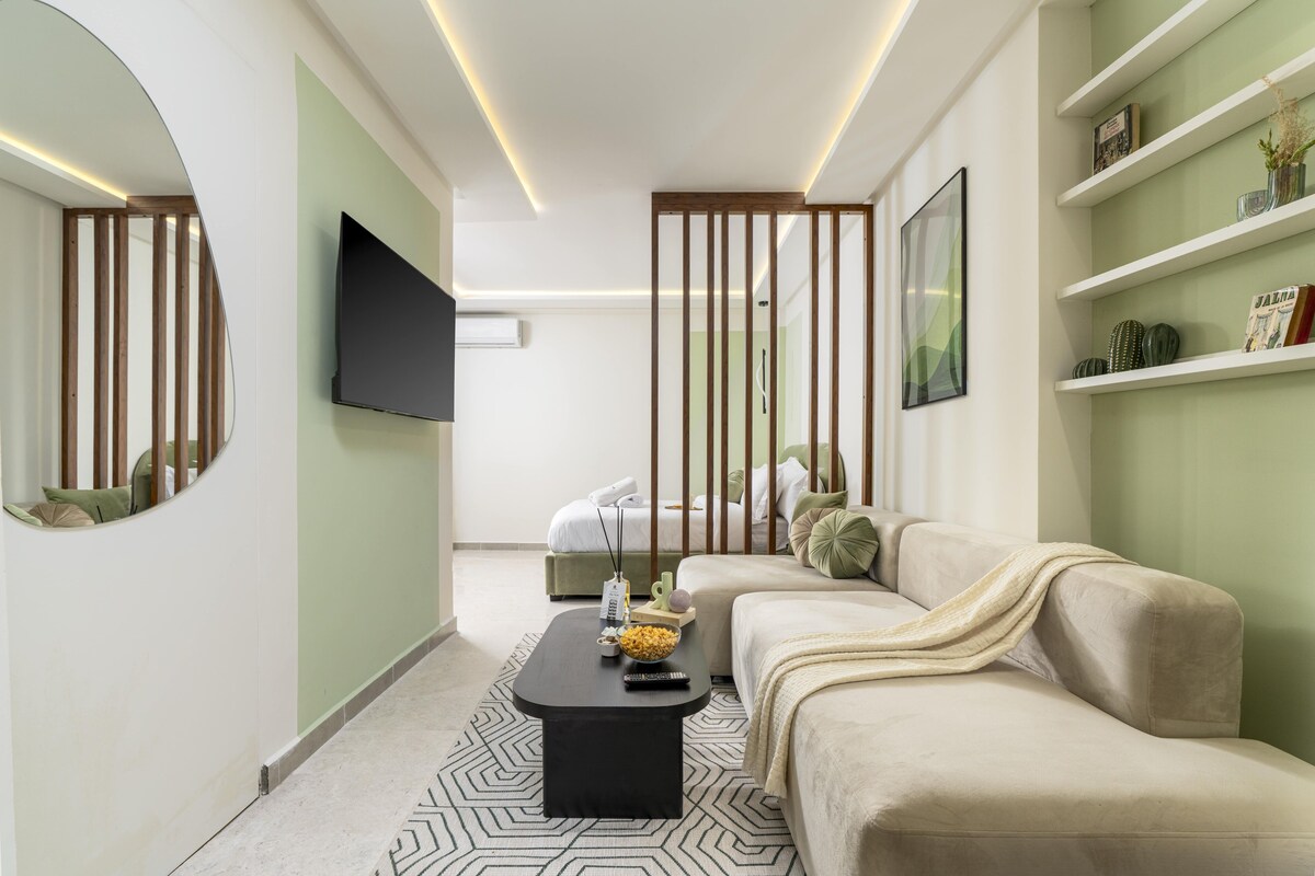 Una sala de estar moderna con sofá, mesa de centro, televisor y estantería.