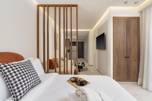 Une chambre d’hôtel avec un lit, une cloison en bois, un téléviseur fixé au mur et une armoire.