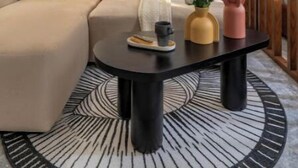 Un salon moderne avec un canapé, une table basse et un tableau accroché au mur.