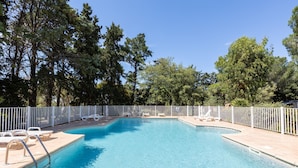 A rectangular swimming pool with a white fence, surrounded by trees and equipped with lounge chairs. - Mobile Home 'Village Camping De L'Ostriconi 28' with Sea View, Shared Pool and Wi-Fi (Palasca)
