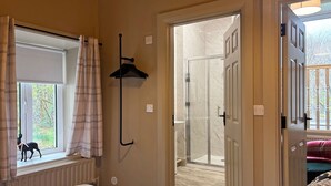 A room with a bed, a window with curtains, a coat rack, and a door leading to a bathroom. - Property 472 - Kylemore - sleeps 20 guests  in 11 bedrooms (Kylemore)