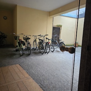 A room with a tiled floor, a yellow wall, and a door leading outside. - The walls of lovers (Verona)