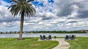 A palm tree, outdoor seating area, and a body of water. - Coastal Oasis on Siesta Key: 1BR Condo + Boat Dock Access (Sarasota)
