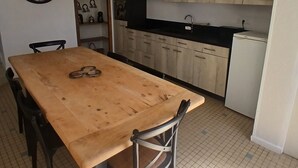 A kitchen with a wooden table, chairs, a sink, and cabinets. - The Gartempe Cottage (Saint-Sornin-la-Marche)