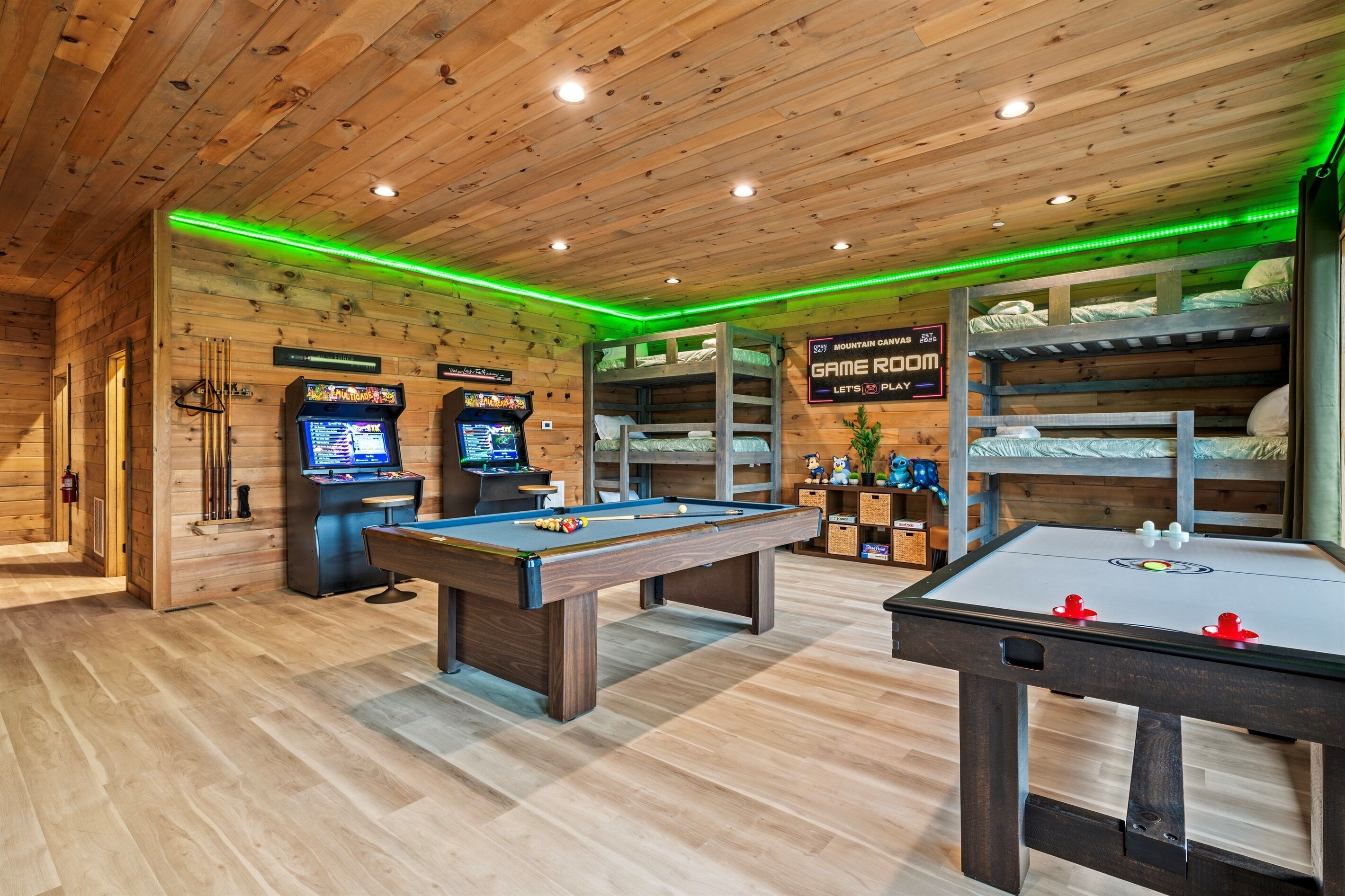 Ein Holzraum mit Billardtisch, Kicker und zwei Spielautomaten.