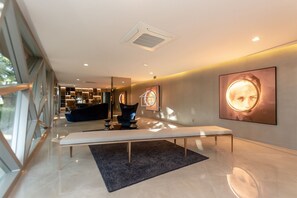 Ein modernes Interieur mit einer Bank, einem Sofa und einem großen Kunstwerk an der Wand.