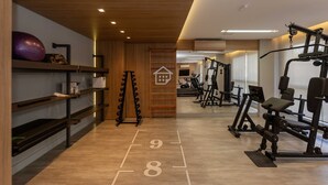 A gym with exercise equipment, wooden walls, and a mirrored wall. - Studio Cubanos | Hub Tecnológico + Lado da PUCRS (Porto Alegre)