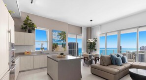 A modern apartment with a kitchen, dining area, and living room, featuring large windows with a city and ocean view. - High Floor 2BR and 2 BA, Free Parking (Hollywood)