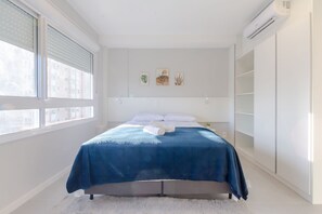 A bedroom with a bed, a window, and a white wall with three small artworks. - Studio | Praticidade ao lado da PUCRS (Porto Alegre)