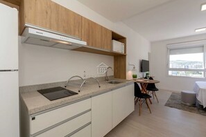 Eine moderne Küche mit eingebautem Herd, einer Spüle und einem Essbereich inklusive Tisch und Stühlen.