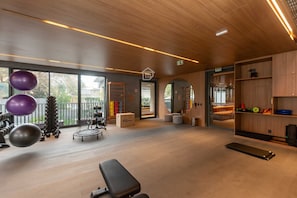 Una palestra moderna con attrezzature per esercizi, una panca e uno specchio.